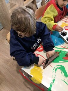 kids doing some painting sitting down at a table.
