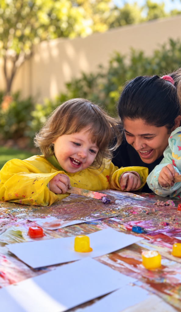 An educator sharing a joyful painting activity with young children