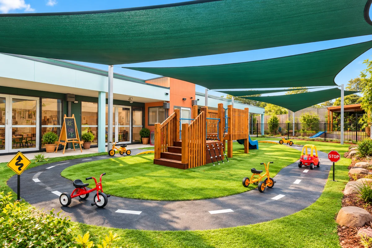 Caterpillar Kidz Dandenong outdoor play area with shade sails, climbing equipment and bike track