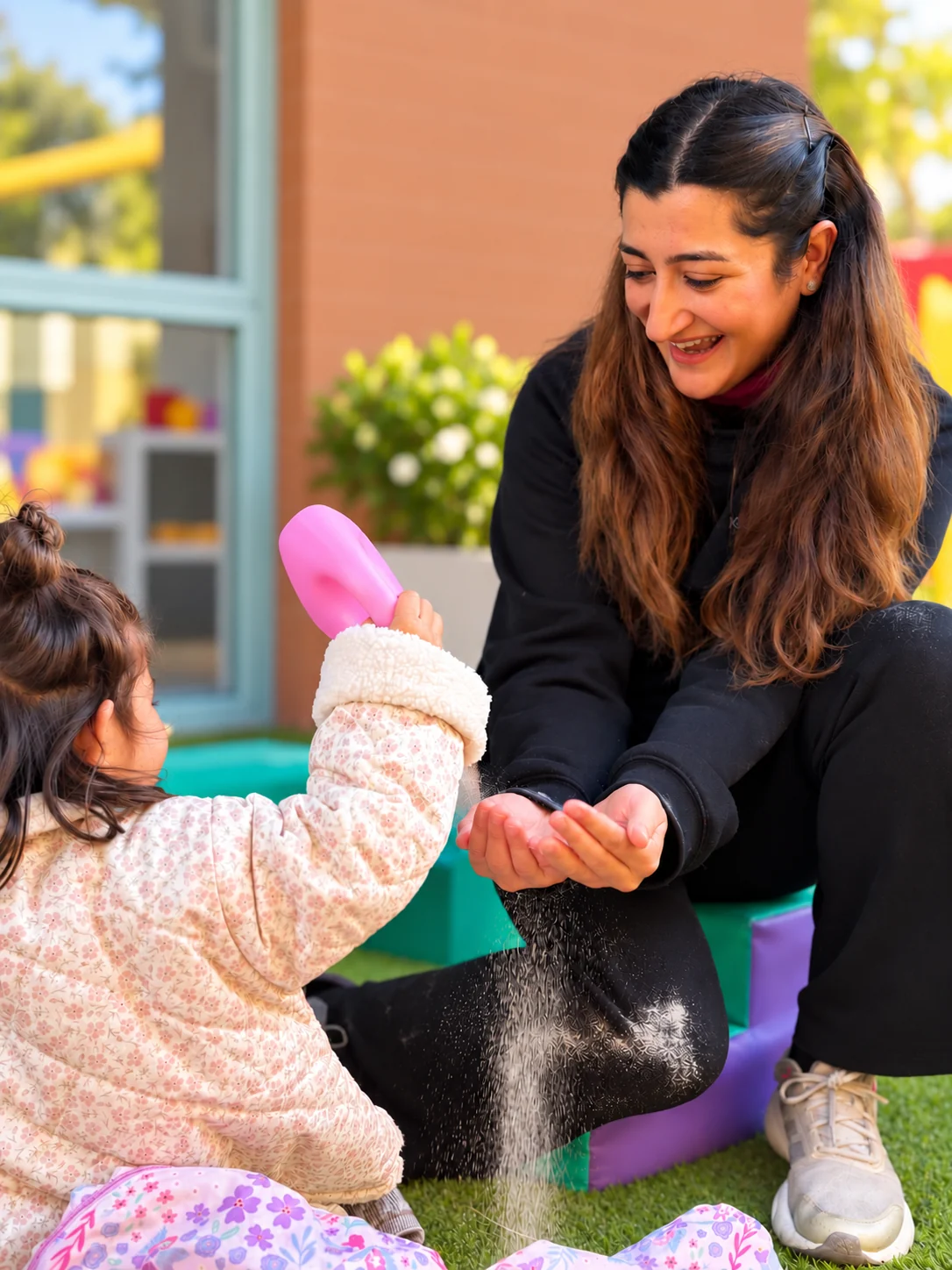 An educator sharing a playful moment with a child at Kidz R Kidz